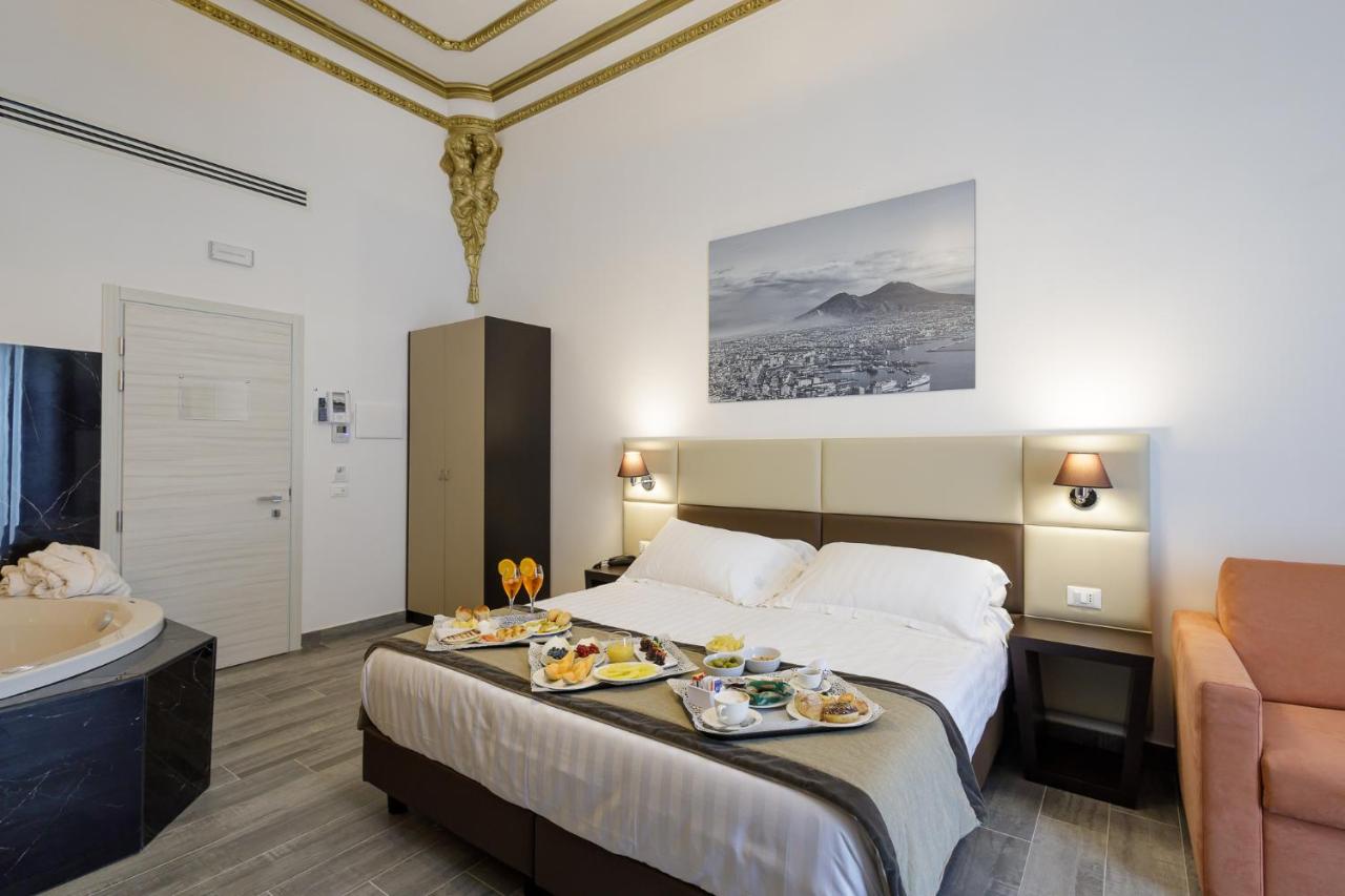 een hotelkamer met een bed en een badkuip bij Hotel Palazzo Argenta in Napels