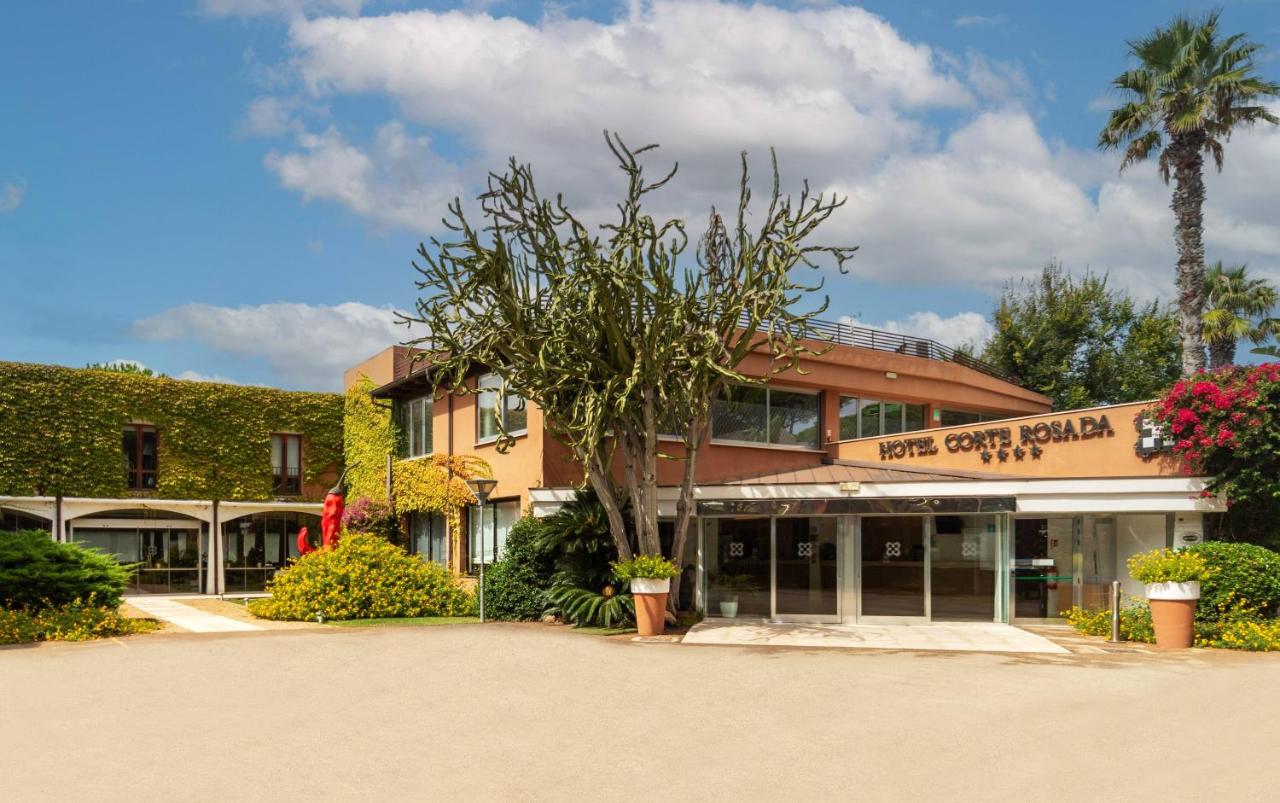 een gebouw met een palmboom ervoor bij Hotel Corte Rosada - Adults Only, Affiliated by Meliá in Porto Conte