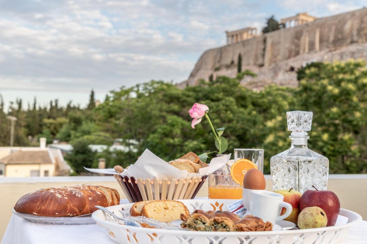 een tafel met een bord eten en een fles wijn bij Kyria Boutique House in Athene