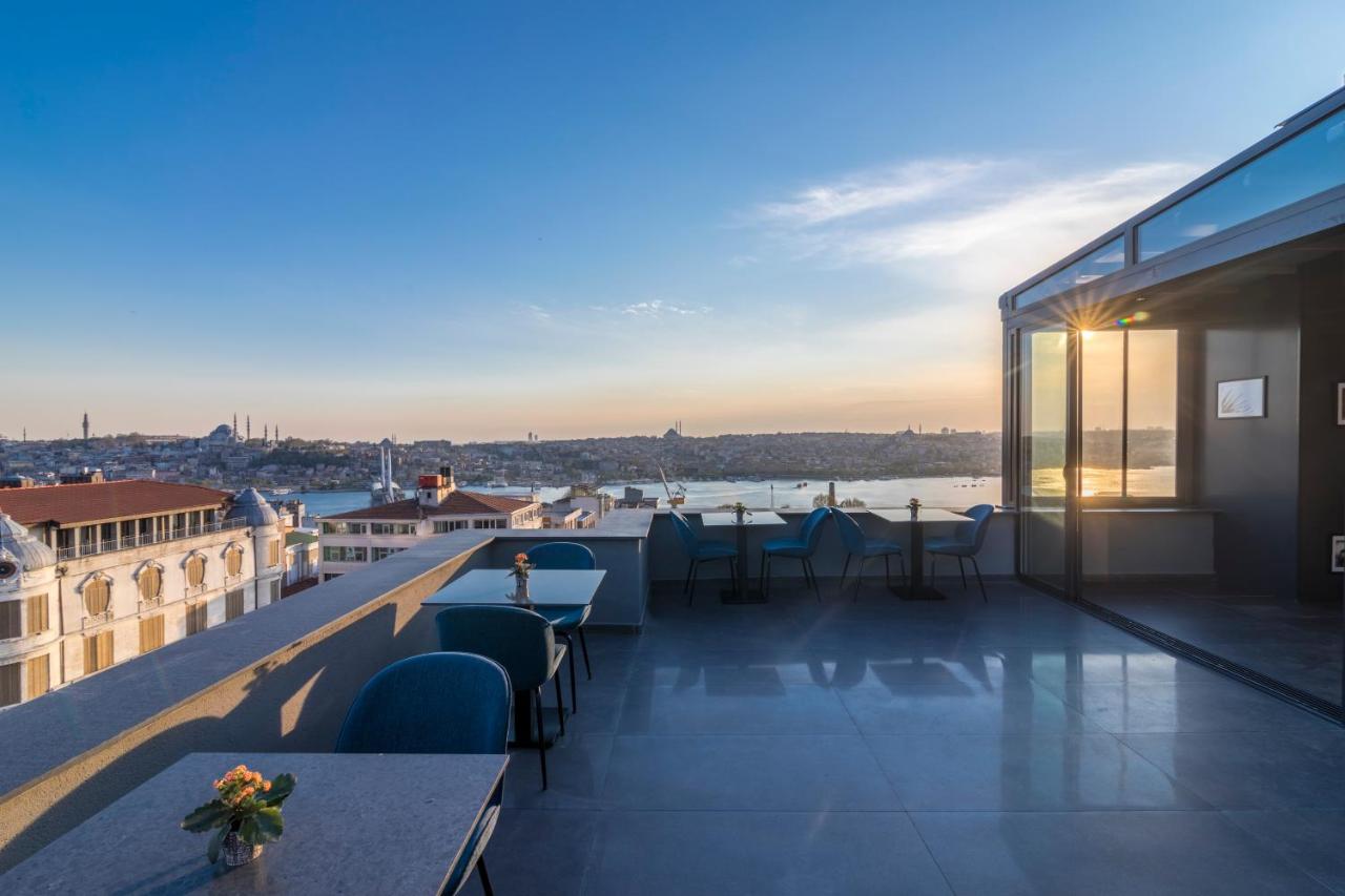 een balkon met tafels en stoelen aan een gebouw bij Galata Times Hotel in Istanbul