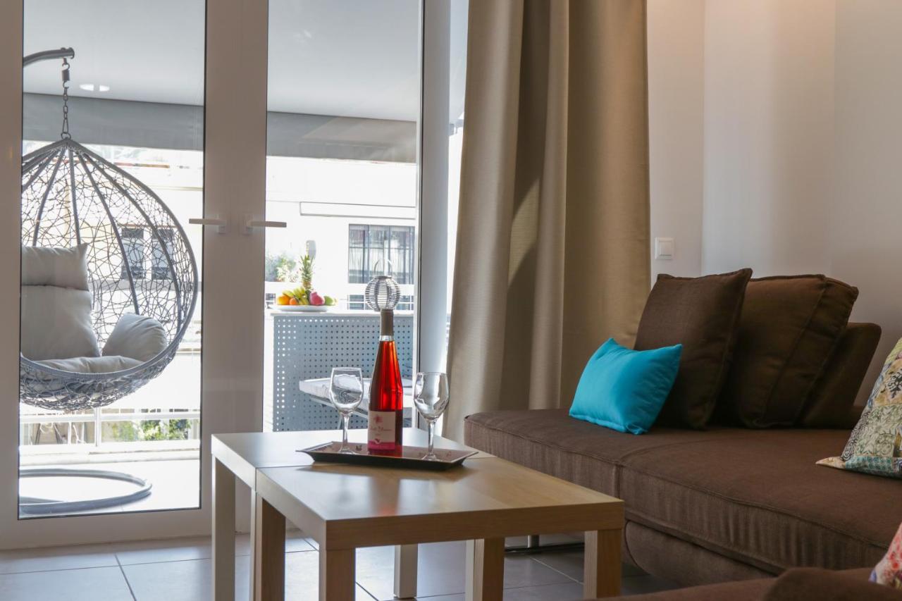 een woonkamer met een bank en een tafel met wijnglazen bij V36 Suites in Athene