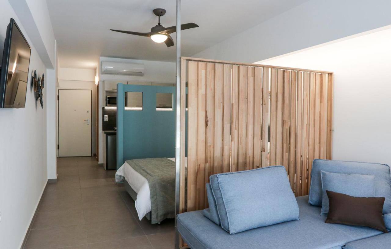 een slaapkamer met een bed, een bank en een plafondventilator bij V36 Suites in Athene