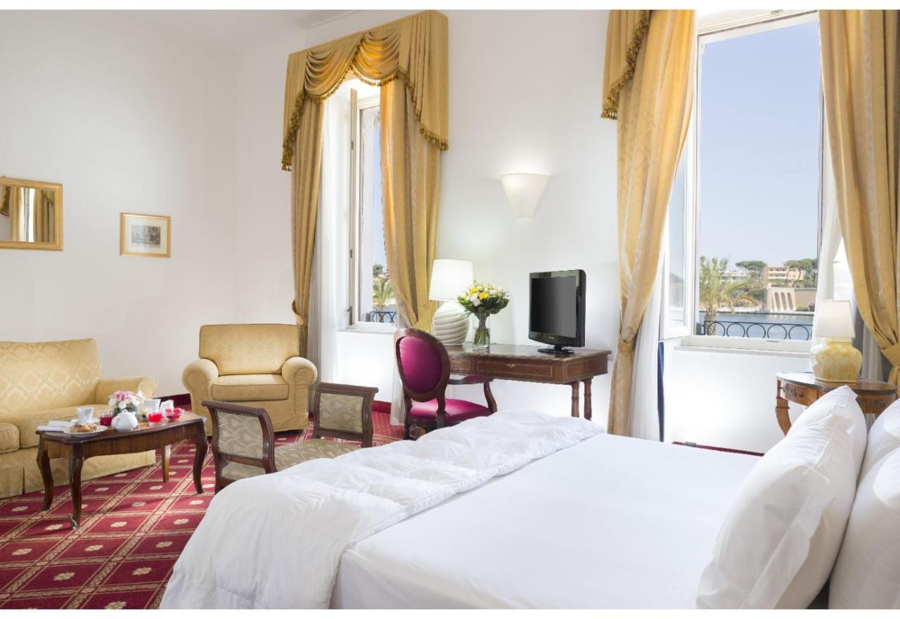 een hotelkamer met een bed, een bureau en een tv bij Grande Albergo Internazionale in Brindisi