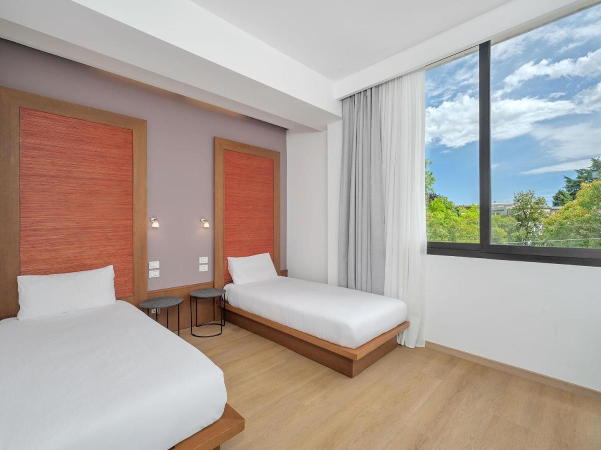 een slaapkamer met twee bedden en een raam bij B&B HOTEL Padova Methis in Padua