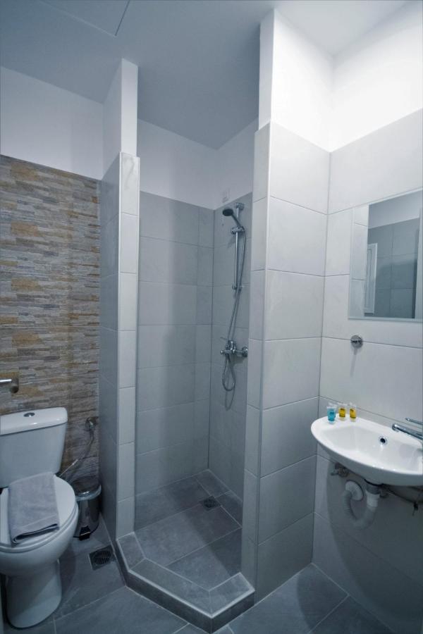 een badkamer met een douche, een toilet en een wastafel bij Athens Psiri Hotel in Athene