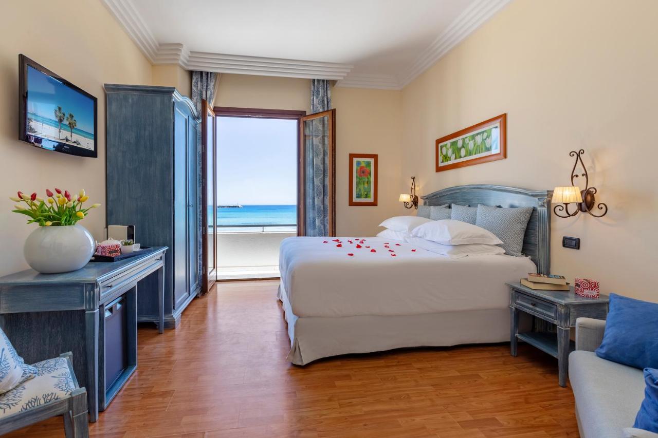 een slaapkamer met een bed en uitzicht op de oceaan bij Mira Spiaggia in San Vito lo Capo