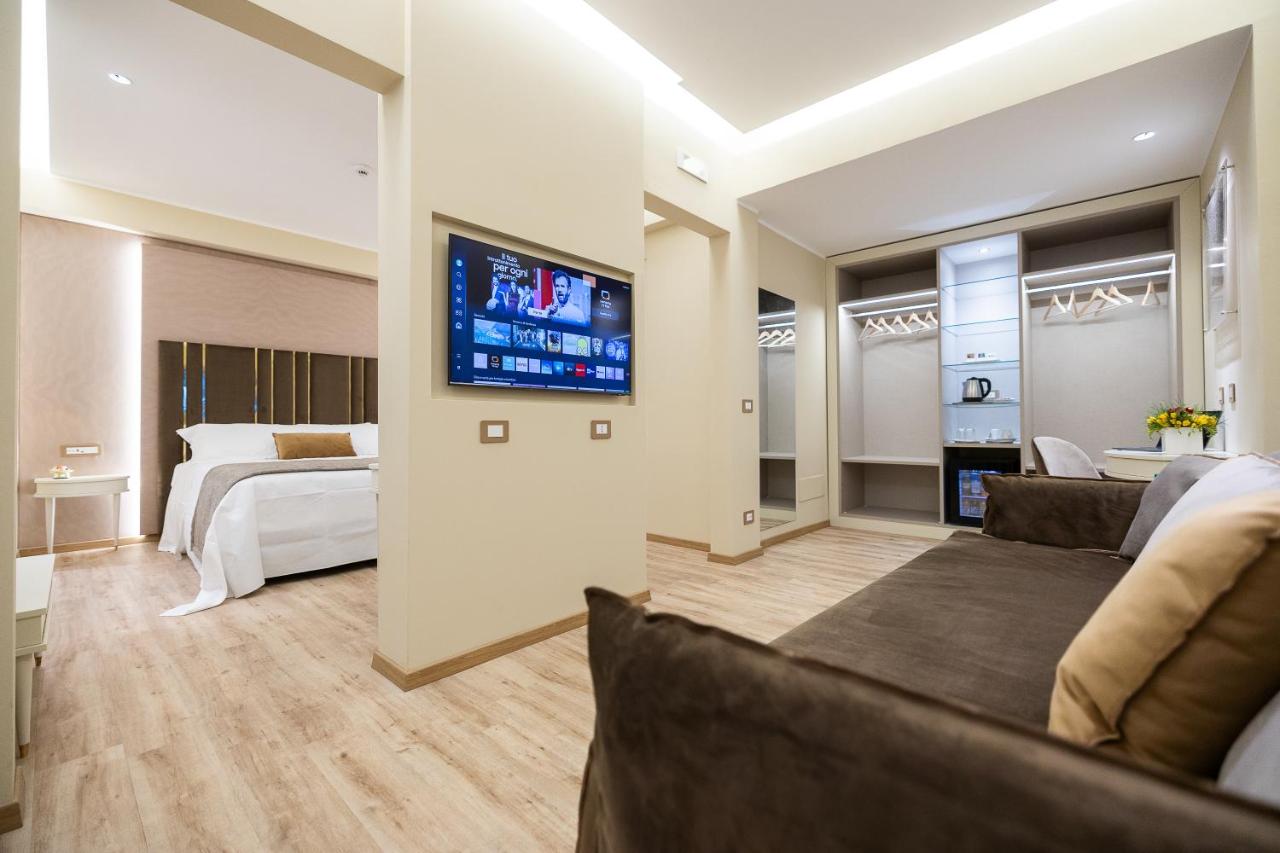 een woonkamer met een bed en een tv aan de muur bij Hotel Montreal in Ragusa