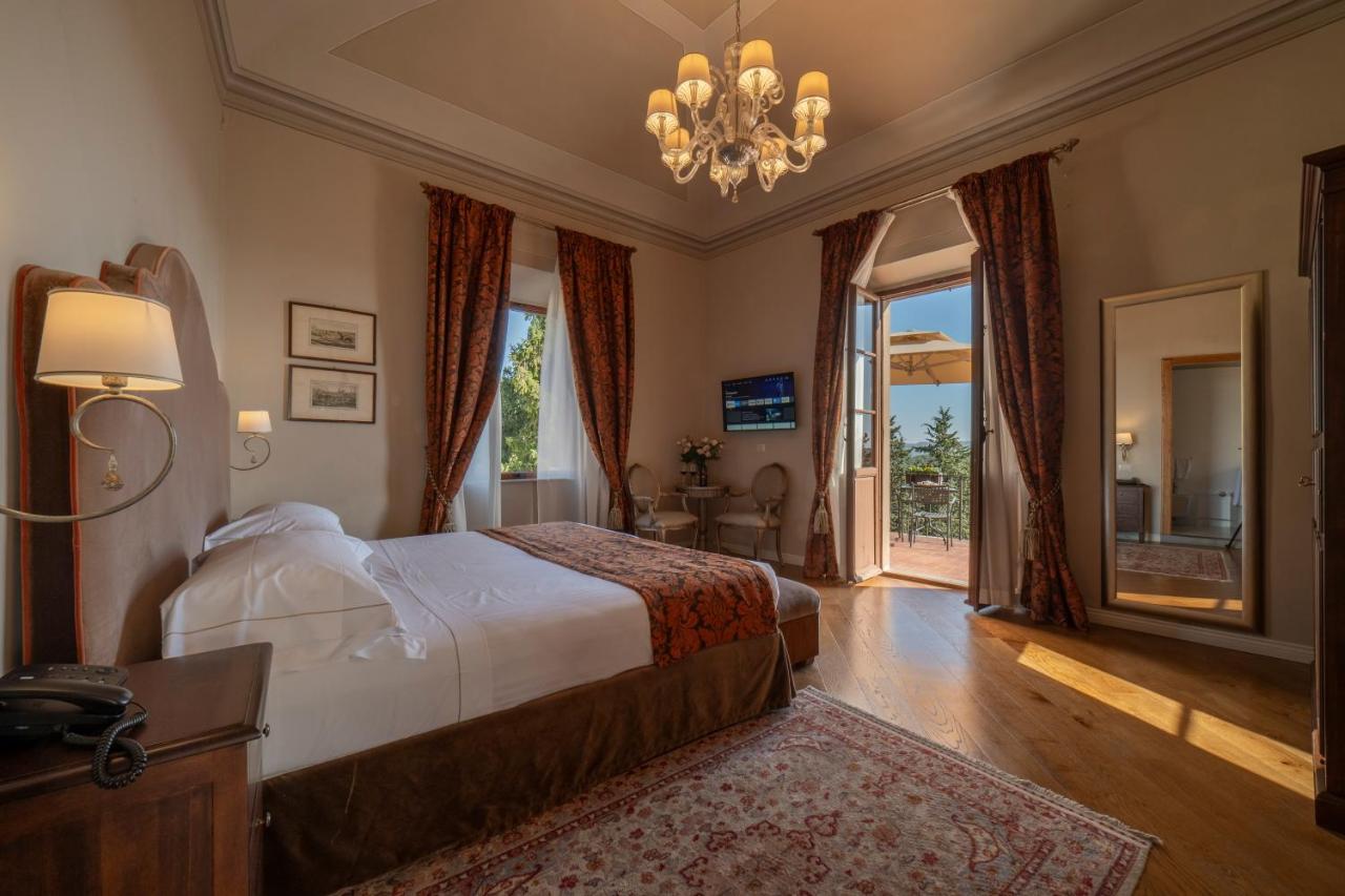 een slaapkamer met een bed en een groot raam bij Palazzo Leopoldo Dimora Storica & Spa in Radda in Chianti +129 foto's