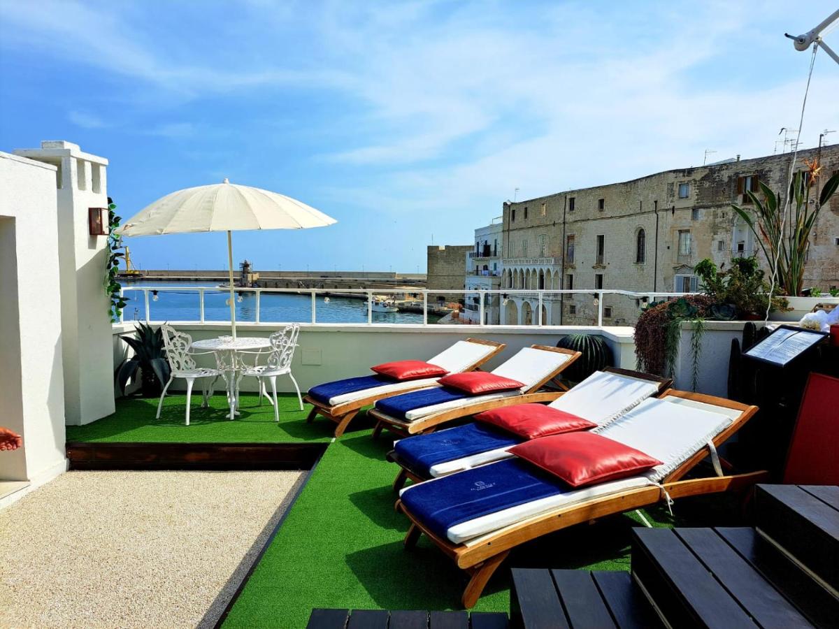 een rij ligstoelen op een balkon met een tafel bij AL CONSOLE LUXURY SUITE in Monopoli