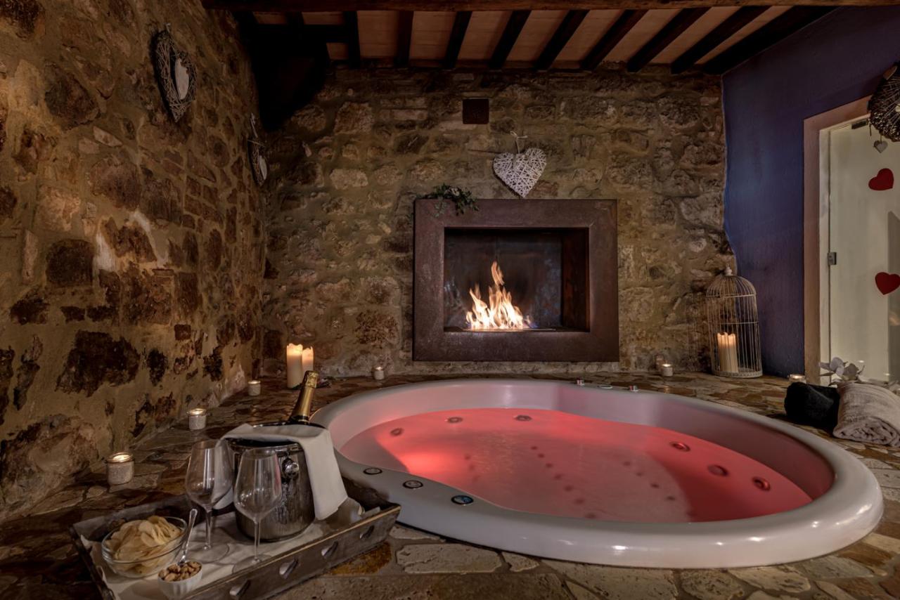 een groot bad in een kamer met een open haard bij PALAZZO DEL CAPITANO Wellness & Relais - Luxury Borgo Capitano Collect