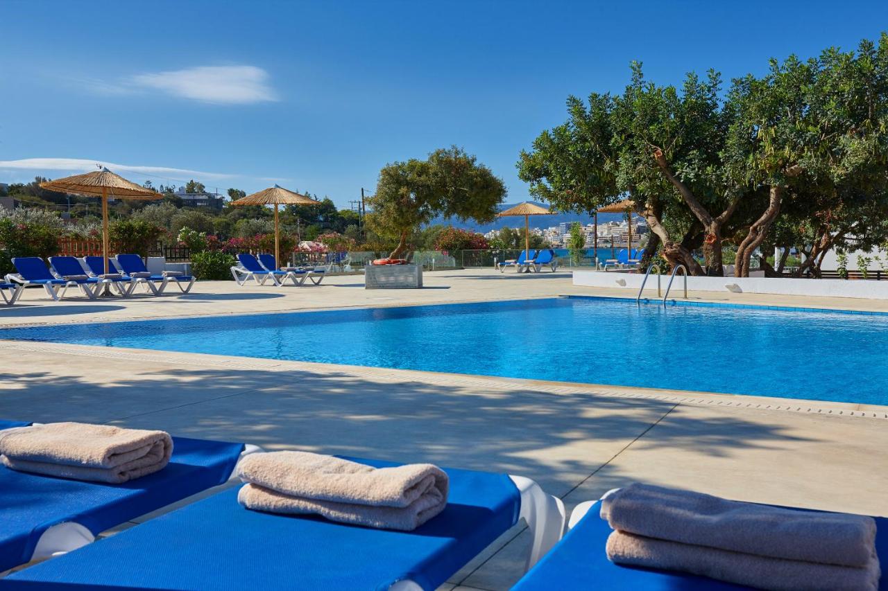 een zwembad met twee blauwe ligstoelen ernaast bij Vasia Ormos Hotel (Adults Only) in Agios Nikolaos