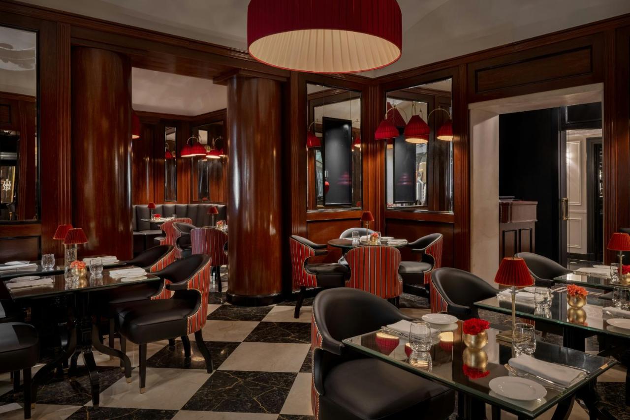 een restaurant met tafels en stoelen en een kroonluchter bij Hotel d’Inghilterra Roma – Starhotels Collezione in Rome