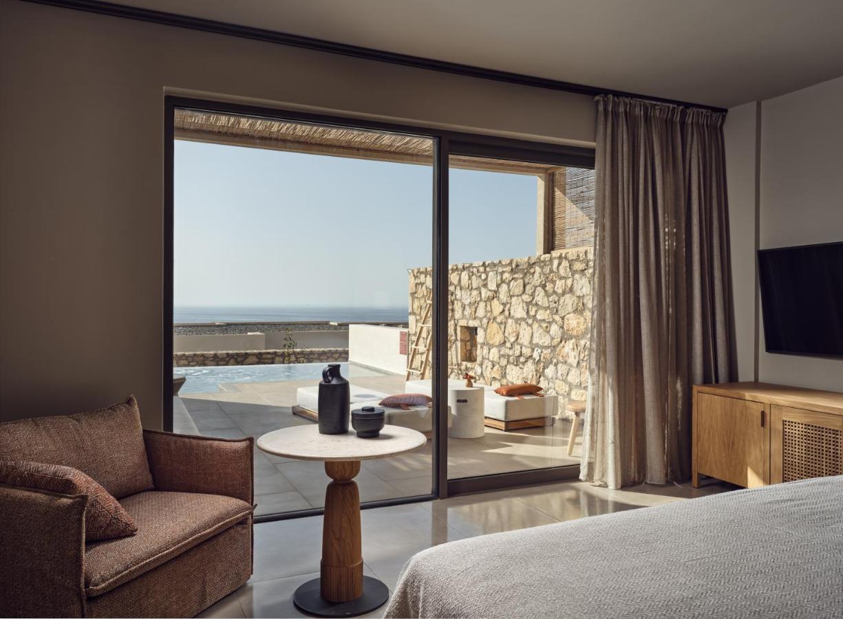 een slaapkamer met een bed, een bank en een tafel bij The Royal Senses Resort & Spa Crete, Curio Collection by Hilton in