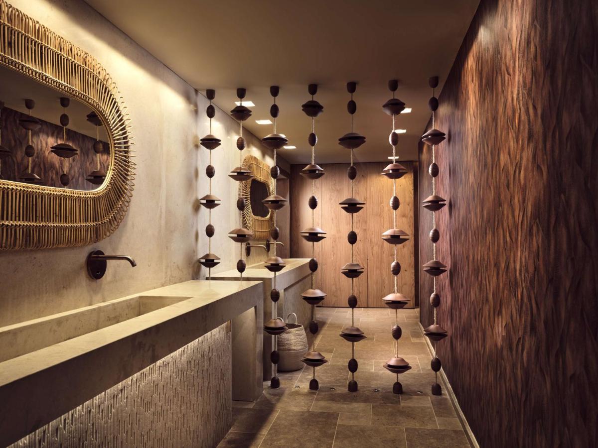 een badkamer met een muur vol knoppen bij The Royal Senses Resort & Spa Crete, Curio Collection by Hilton in Panormos Re