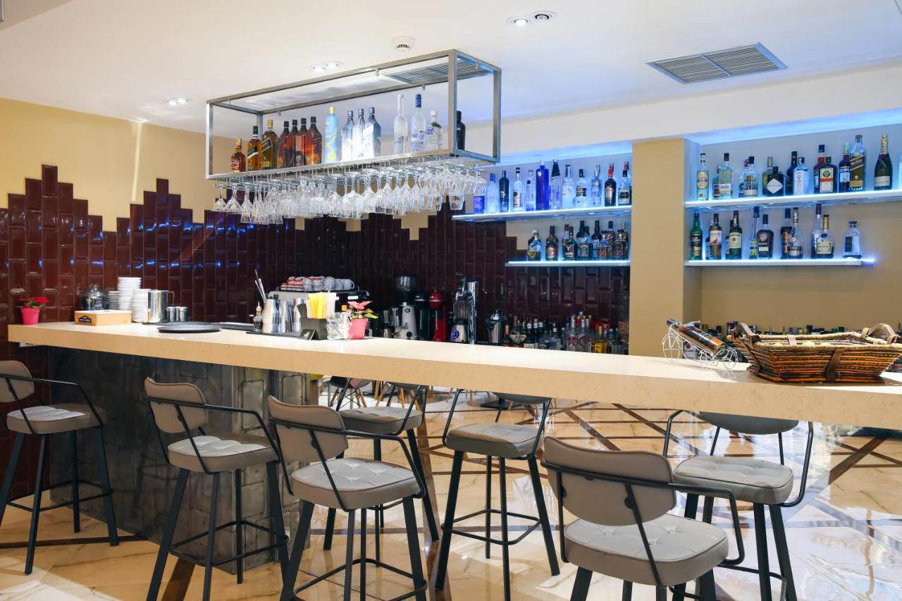 een bar met barkrukken in een kamer met flessen bij Athens Starlight Hotel in Athene