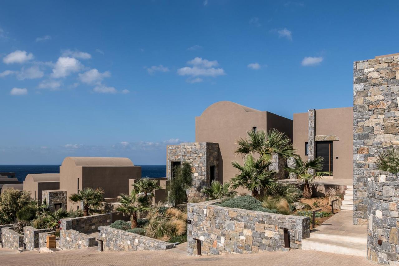 Een impressie van de buitenkant van een resort met palmbomen. bij Acro Suites - A Wellbeing Resort in Agia Pelagia
