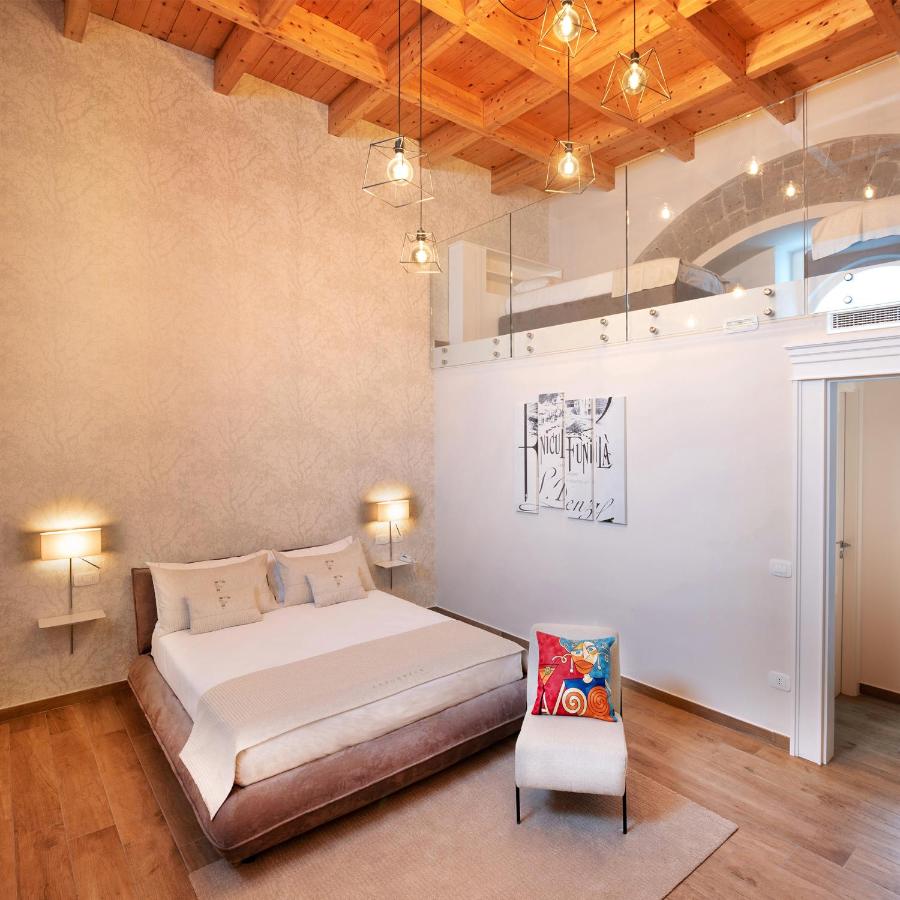 een slaapkamer met een bed en een stoel erin bij La Fornace Relais & Spa in Castellammare di Stabia