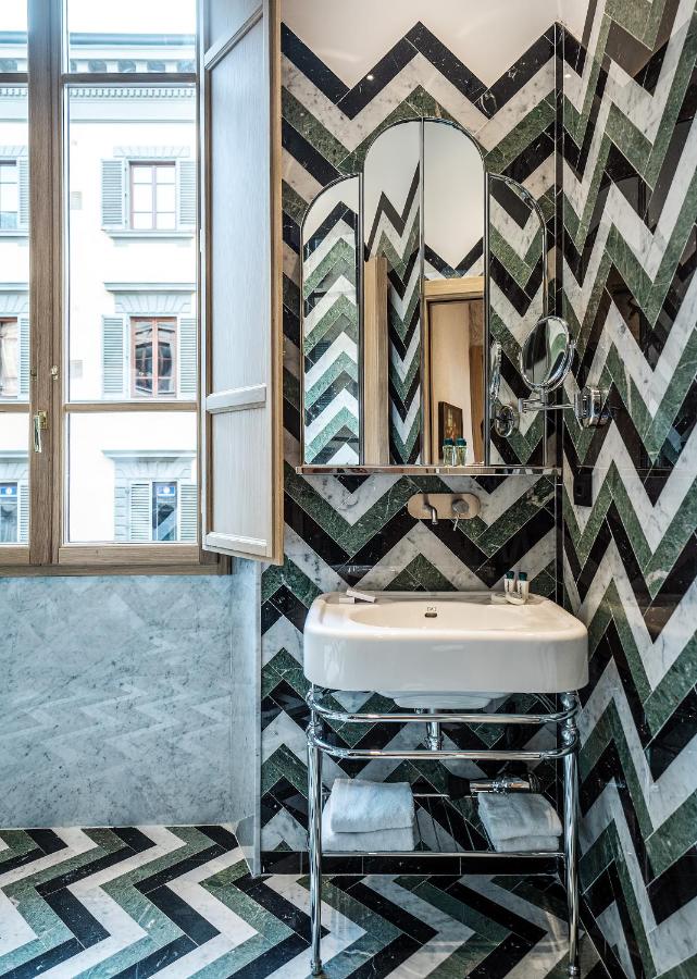 een badkamer met een wastafel en een spiegel bij Hotel Calimala Florence in Florence