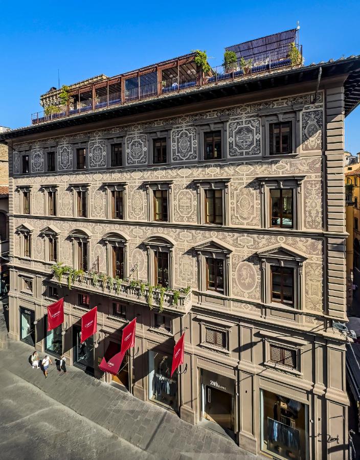 een gebouw met rode vlaggen ervoor bij Hotel Calimala Florence in Florence