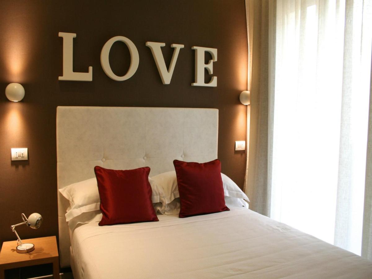 een slaapkamer met een bed en een liefdessymbool aan de muur bij Hotel Select Suites & Spa - Apartments in Riccione