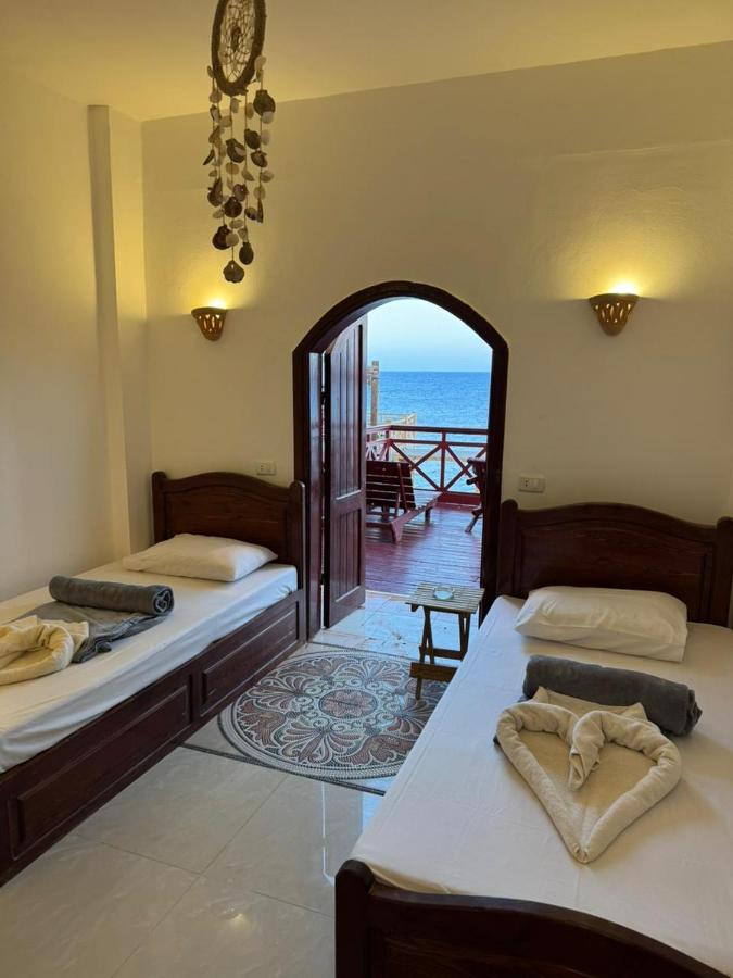 twee bedden in een kamer met uitzicht op de oceaan bij Nirvana Dahab Hotel & Diving Center in Dahab