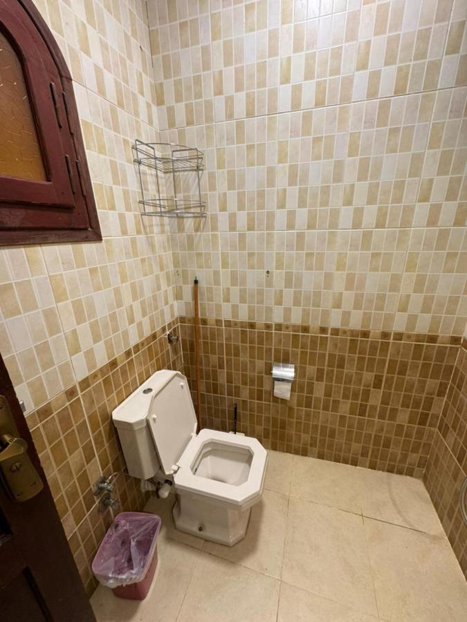 een badkamer met een toilet in een betegelde kamer bij Nirvana Dahab Hotel & Diving Center in Dahab