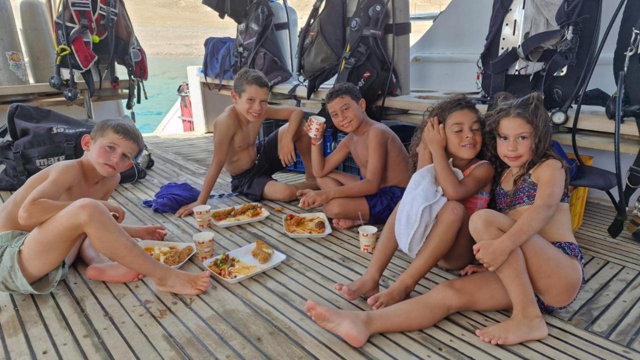 een groep kinderen zit op een terras te eten. bij Nirvana Dahab Hotel & Diving Center in Dahab
