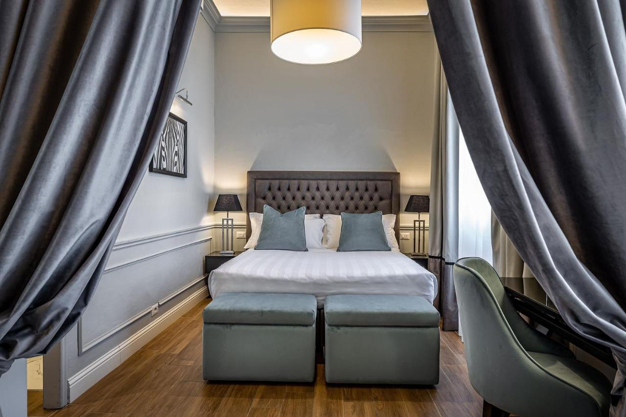 een hotelkamer met een bed en een stoel bij Hotel Ungherese in Florence