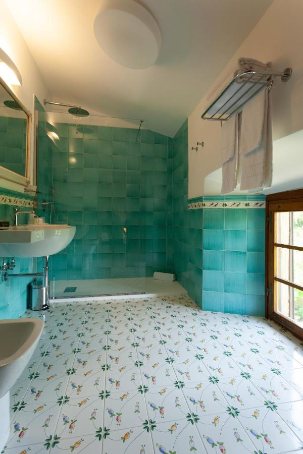 een badkamer met een blauwe tegelvloer en een wastafel bij Hotel Villa San Lucchese in Poggibonsi
