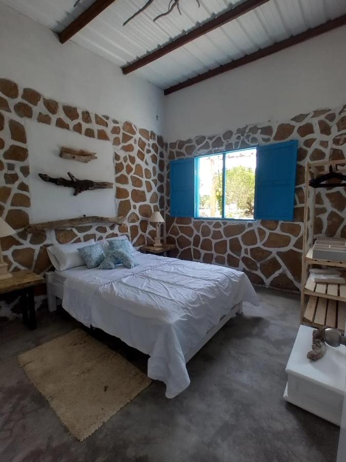 een slaapkamer met een bed in een stenen muur bij Villa Mediterránea in Tubará