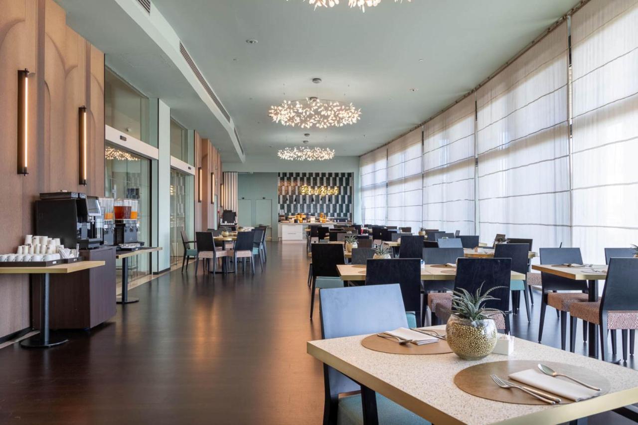 een restaurant met tafels en stoelen en een eetzaal bij DoubleTree by Hilton Florence Metropole in Florence