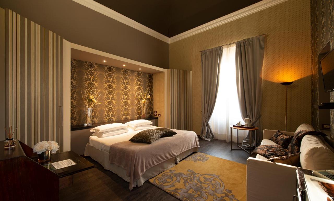 een hotelkamer met een bed en een bank bij Hotel De La Pace, Sure Hotel Collection by Best Western in Florence