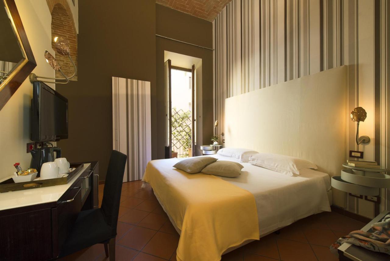 een slaapkamer met een bed, een bureau en een televisie bij Hotel De La Pace, Sure Hotel Collection by Best Western in F