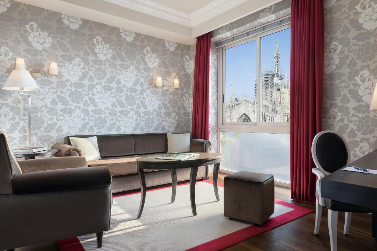 een woonkamer met een bank, een tafel en een raam bij Sina De La Ville in Milaan