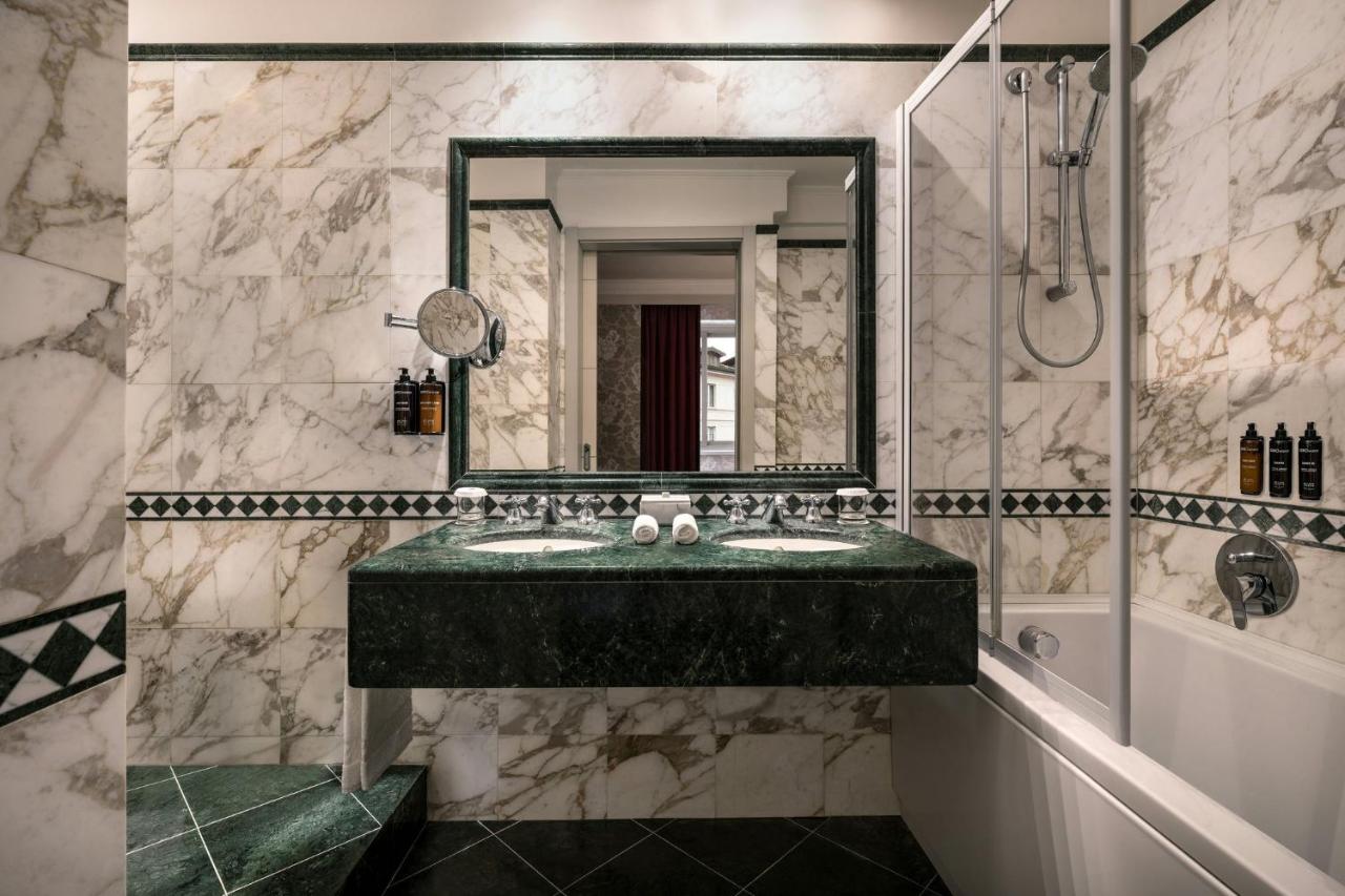 een badkamer met een groene wastafel en een spiegel bij Sina De La Ville in Milaan +26 foto's