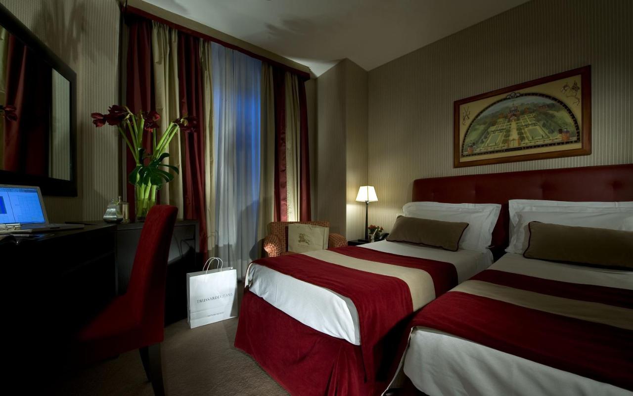 een hotelkamer met twee bedden en een bureau bij Hotel dei Borgognoni in Rome