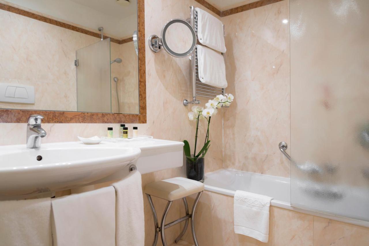 een badkamer met een wastafel, een badkuip en een spiegel bij Hotel dei Borgognoni in Rome