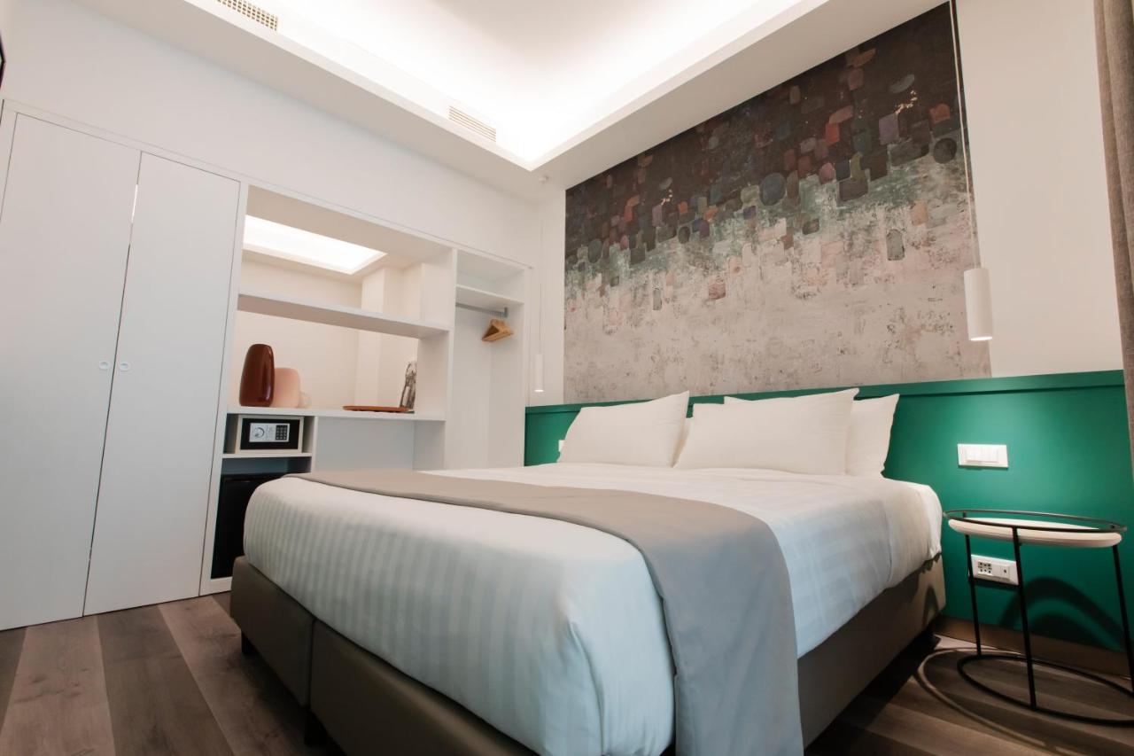 een slaapkamer met een groot bed met een groen hoofdeinde bij Smart Hotel Napoli in Napels