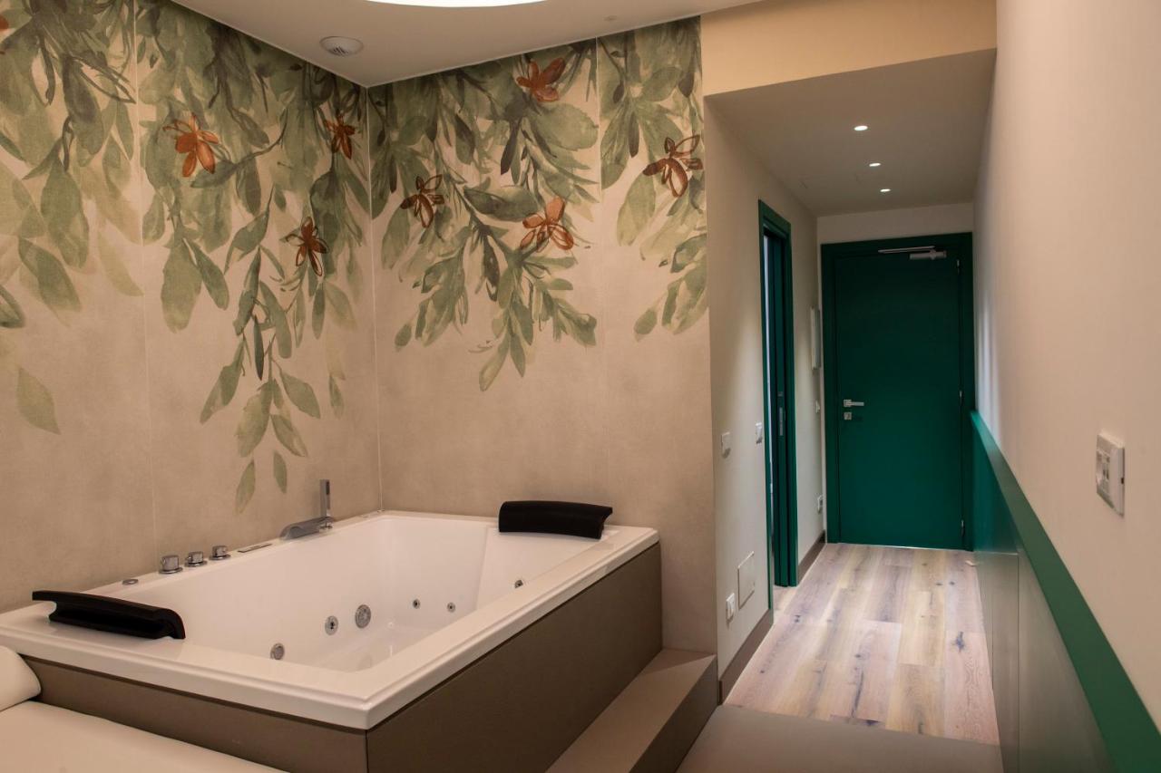 een badkuip in een badkamer met bloemenbehang bij Smart Hotel Napoli in Napels