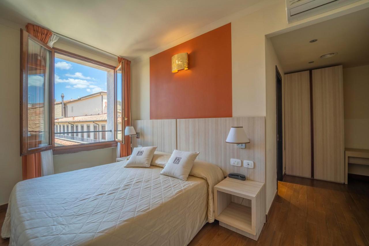 een slaapkamer met een groot bed en een groot raam bij Hotel della Signoria in Florence