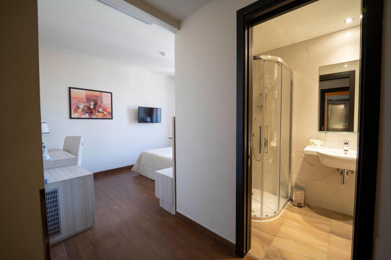 een badkamer met een douche en een wastafel en een bed bij Hotel della Signoria in Florence