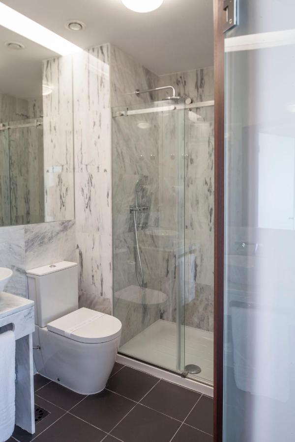een badkamer met een douche, een toilet en een wastafel bij Luzeiros Suites in Lissabon