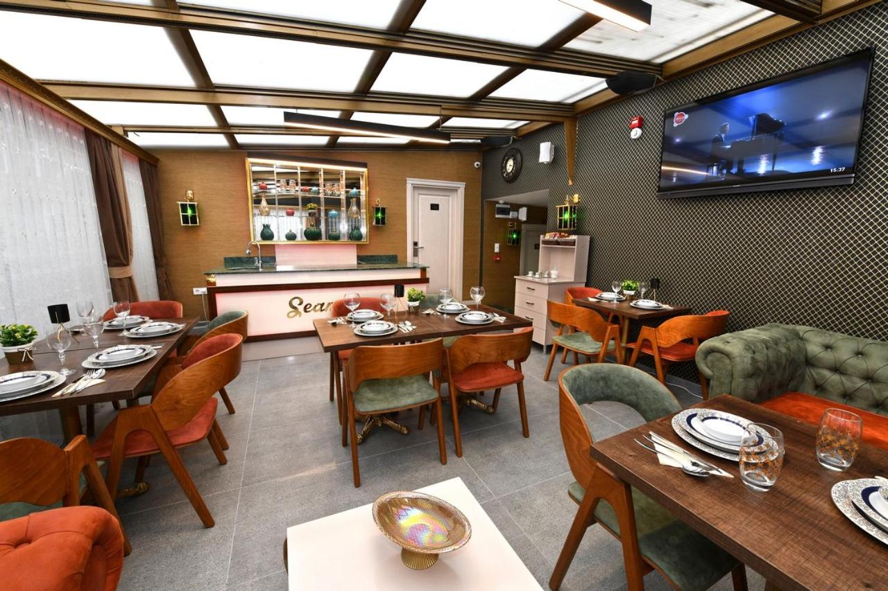 een restaurant met tafels en stoelen en een flatscreen-tv bij Sea Moon Hotel in Istanbul