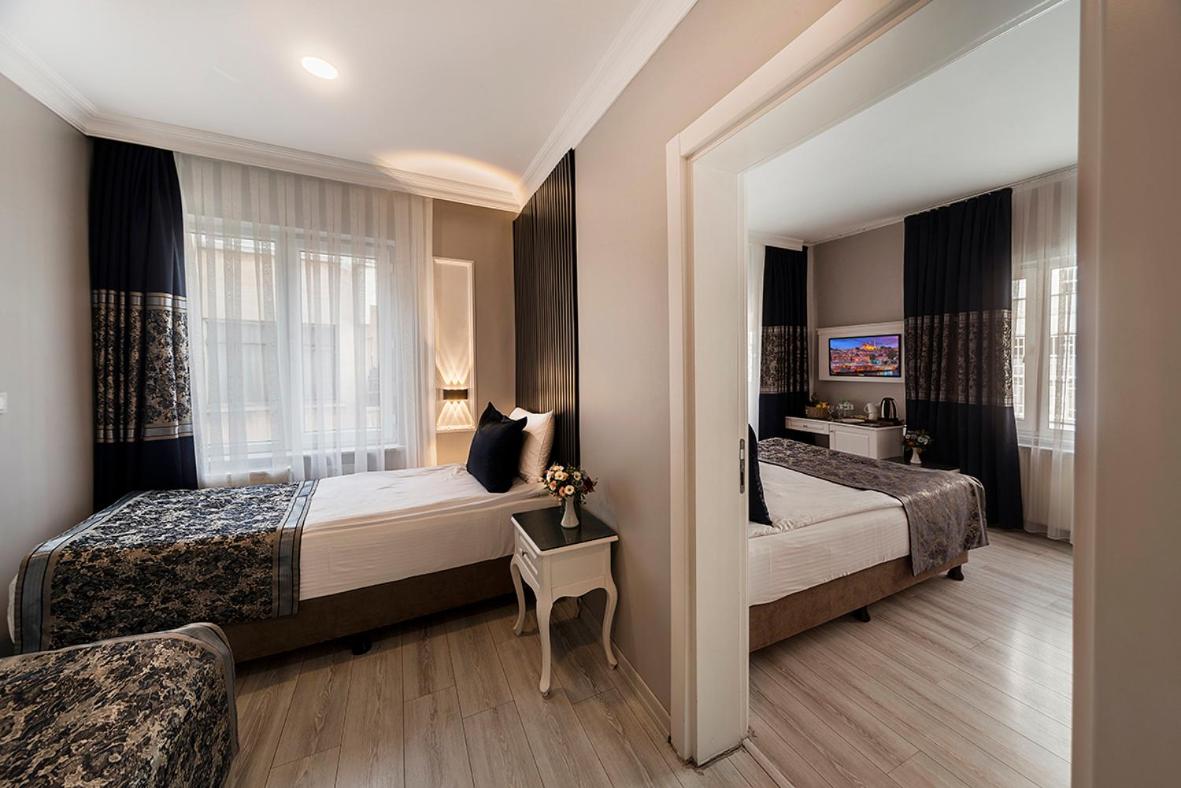 een hotelkamer met twee bedden en een raam bij Beyazit Palace Hotel in Istanbul