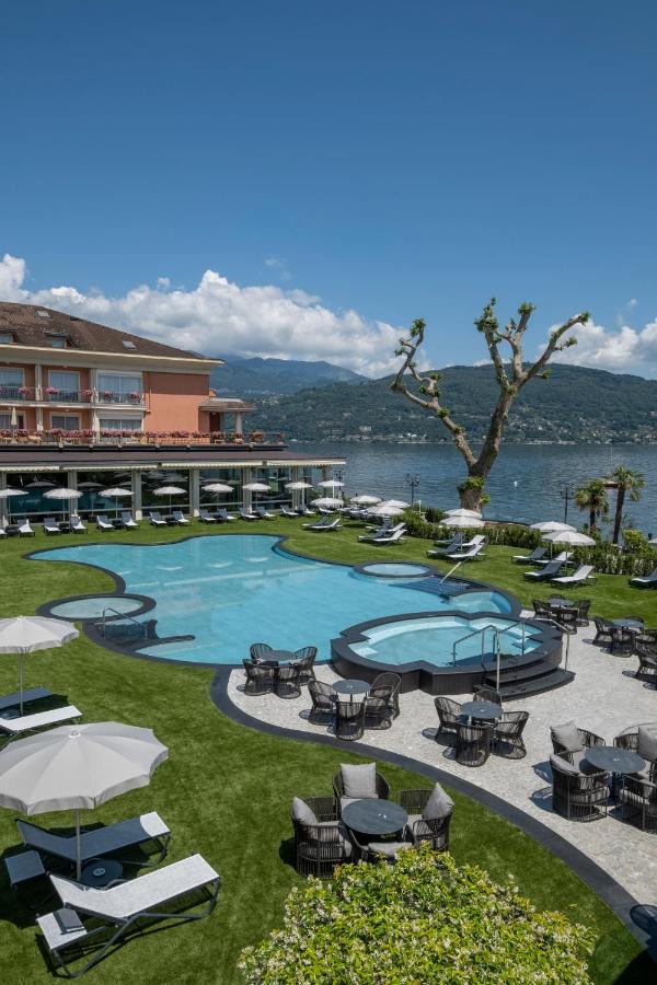 een resort met een zwembad met tafels en stoelen bij Grand Hotel Dino in Baveno