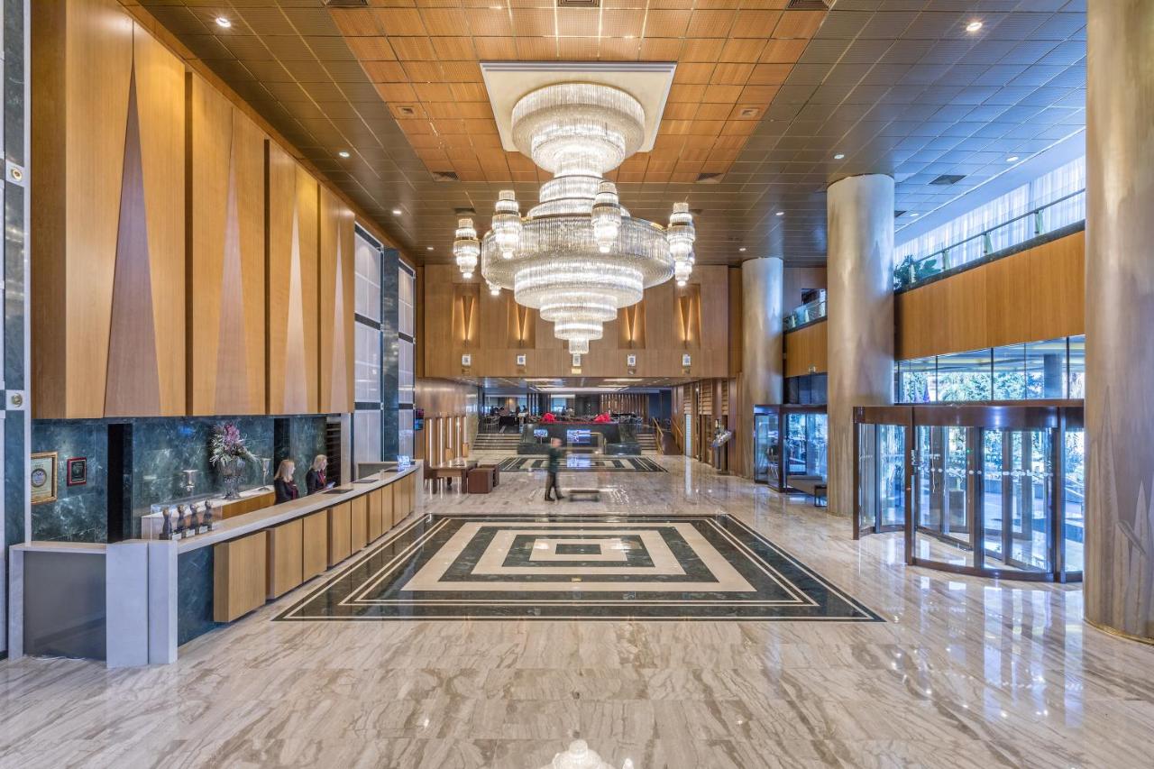 een lobby van een gebouw met een kroonluchter bij Divani Caravel in Athene