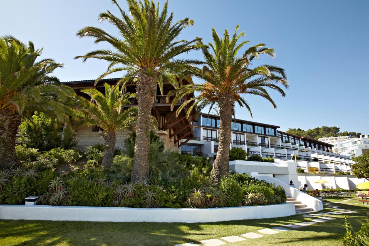 een hotel met palmbomen voor een gebouw bij Hotel do Mar in Sesimbra