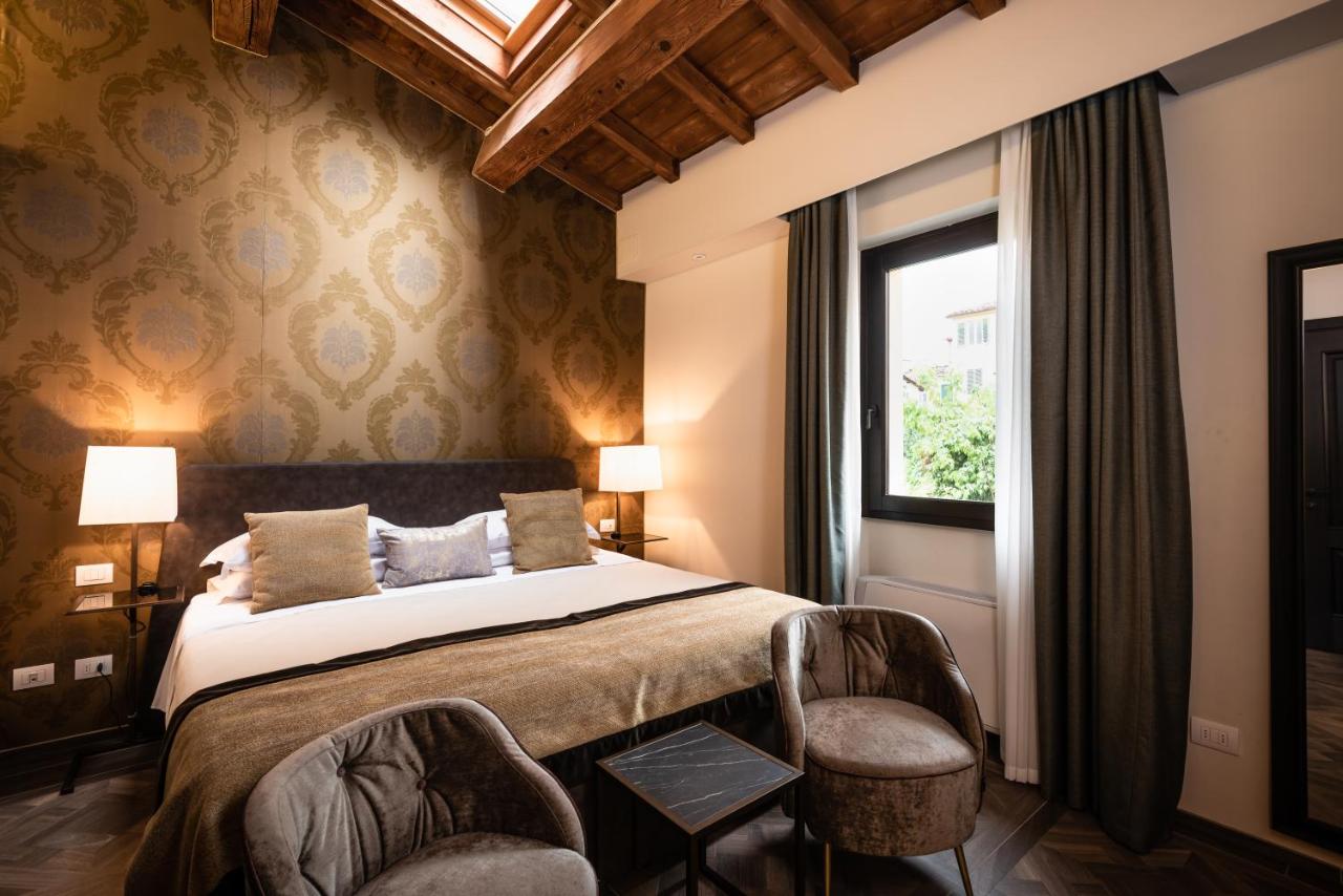 een slaapkamer met een bed met twee stoelen en een raam bij Corte Guelfa in Florence