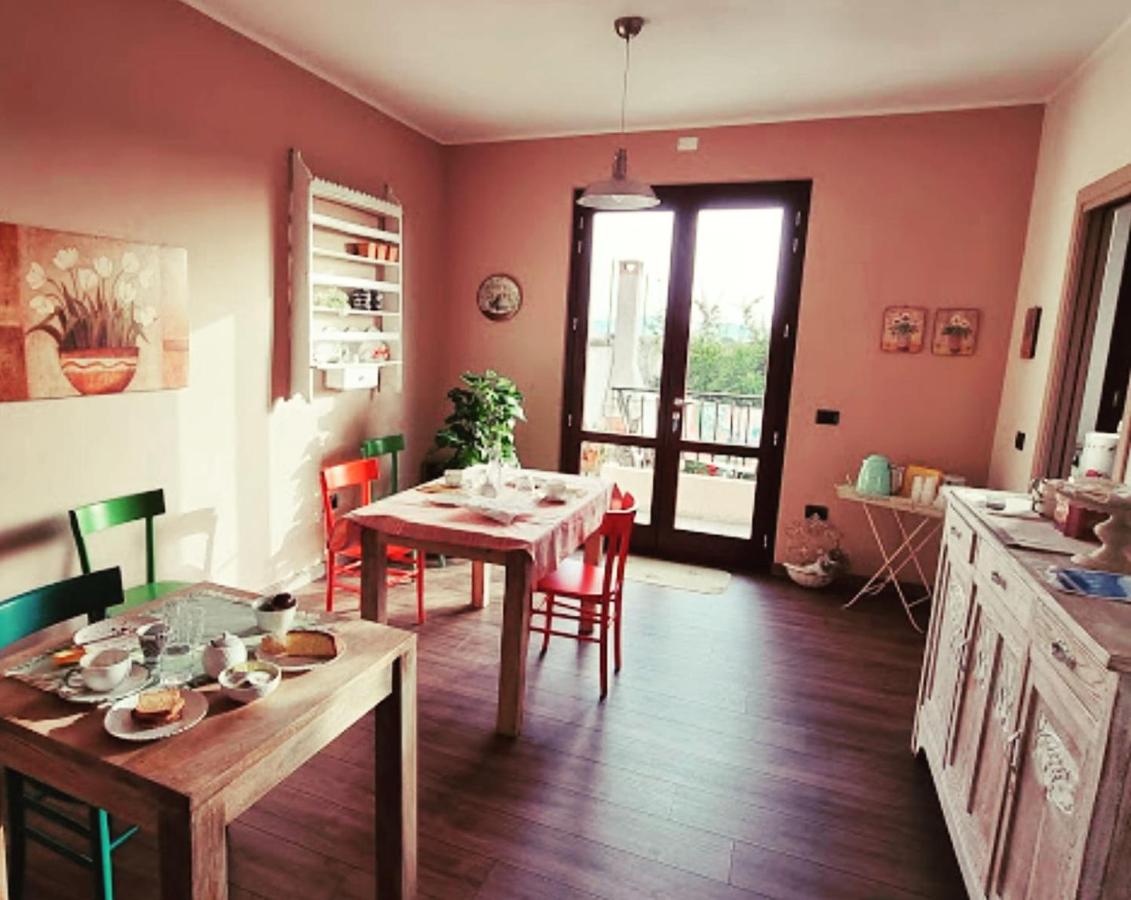 een woonkamer met een tafel en stoelen en een keuken bij B&B al civico16 in Guspini