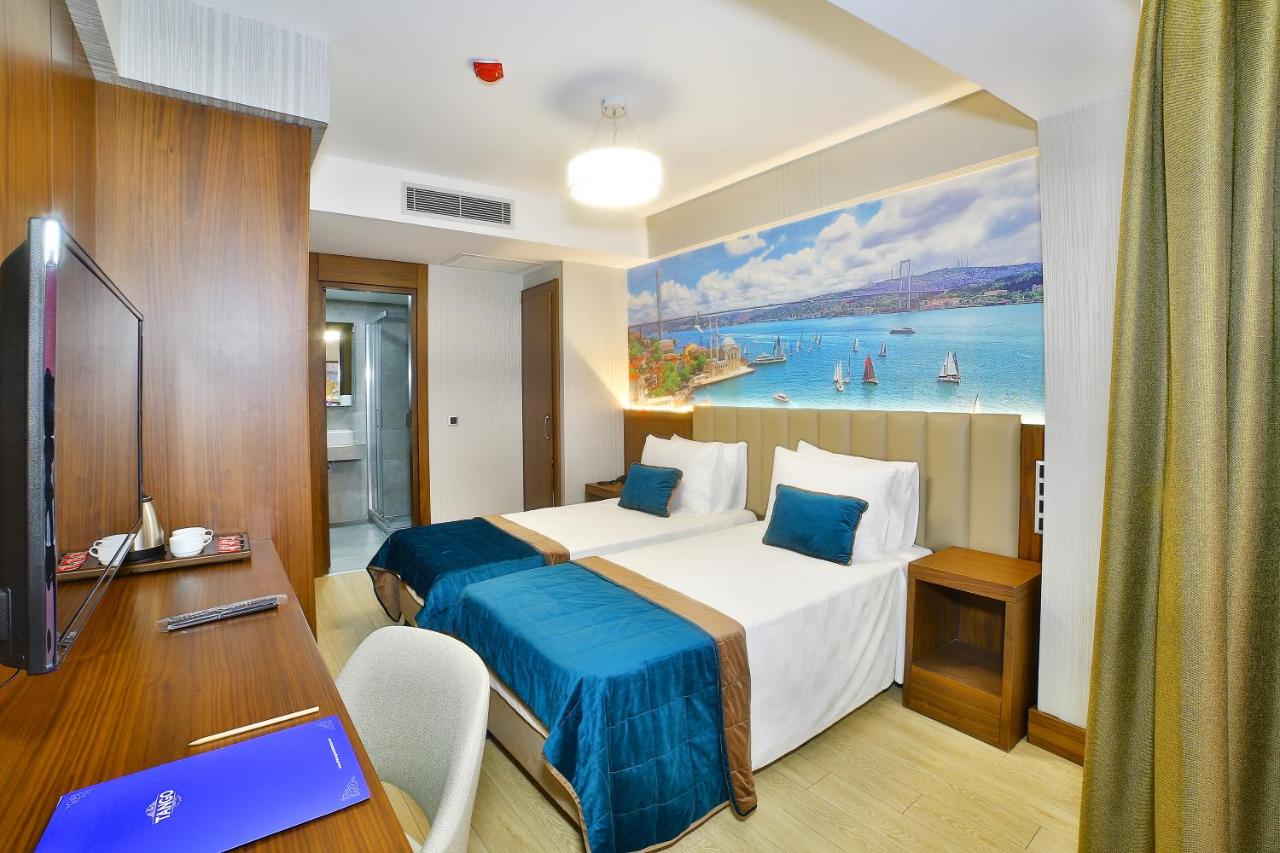 een hotelkamer met twee bedden en een bureau bij The Tango Hotel Taksim in Istanbul